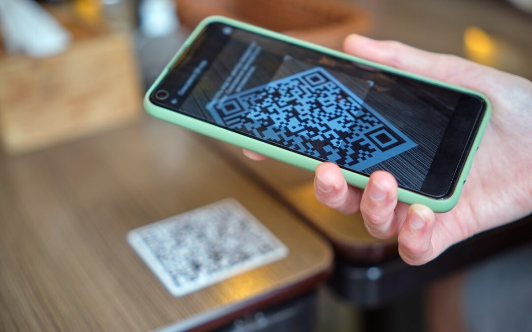 Closeup of guest hand ordering meal in restaurant while scanning qr code with mobile phone, using restaurant order management system.