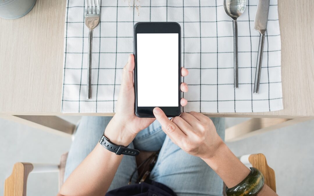 top view of someone using a mobile table ordering system at restaurant