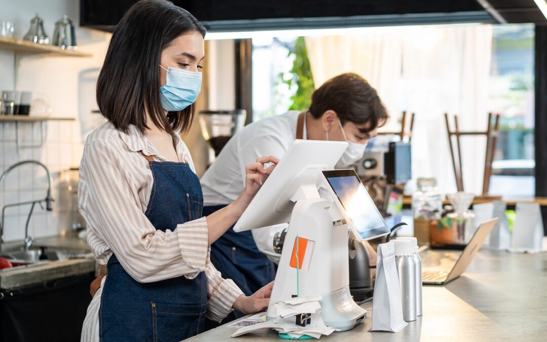 Employee using restaurant order management system to check food order and payment.